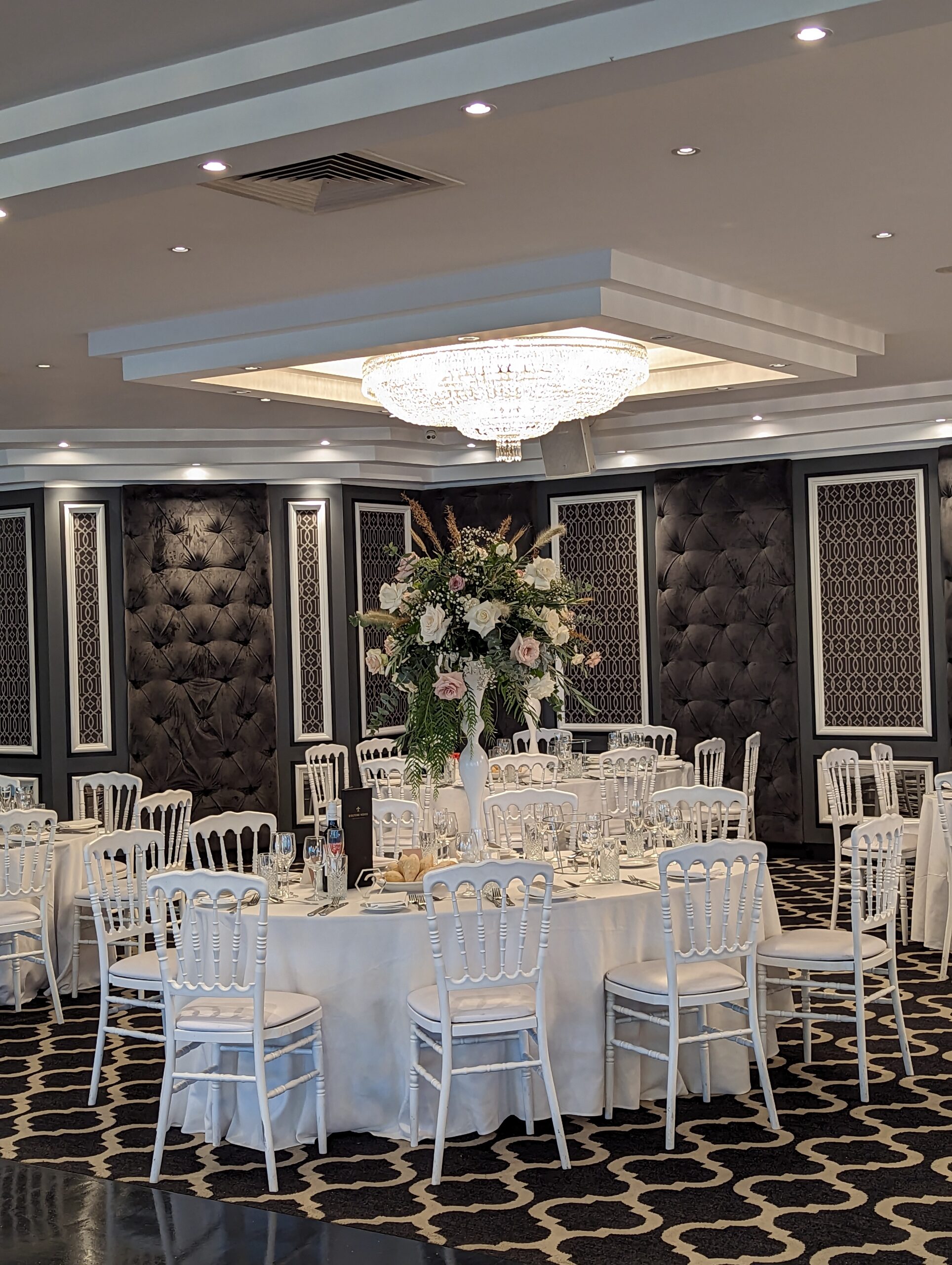 Wedding room with tall vase centerpiece.