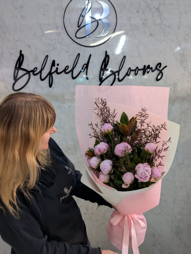 holding a bouquet of peony flowers