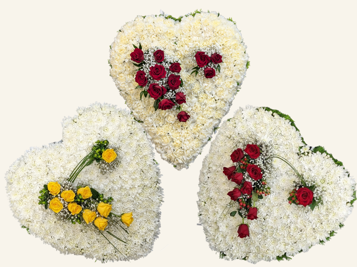 HEART & SOULS Heart Tribute A striking rose heart tribute with a 3D spray of red or yellow roses, finished on a chrysanthemum or carnation base.